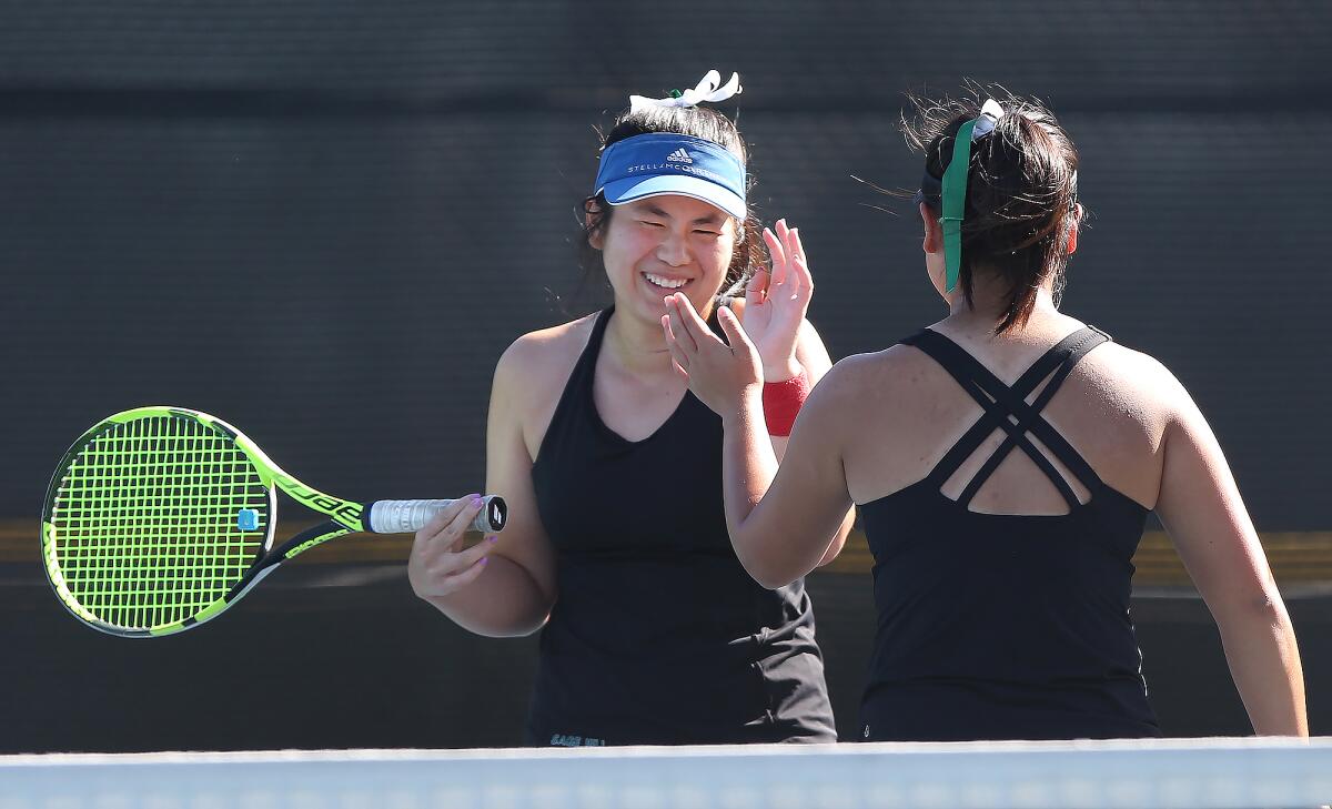 Madison Dao, left, and Julia Yuen celebrate a tough point in a doubles set for Sage Hill against St. Margaret’s during a San Joaquin League match at Saddleback College on Wednesday.