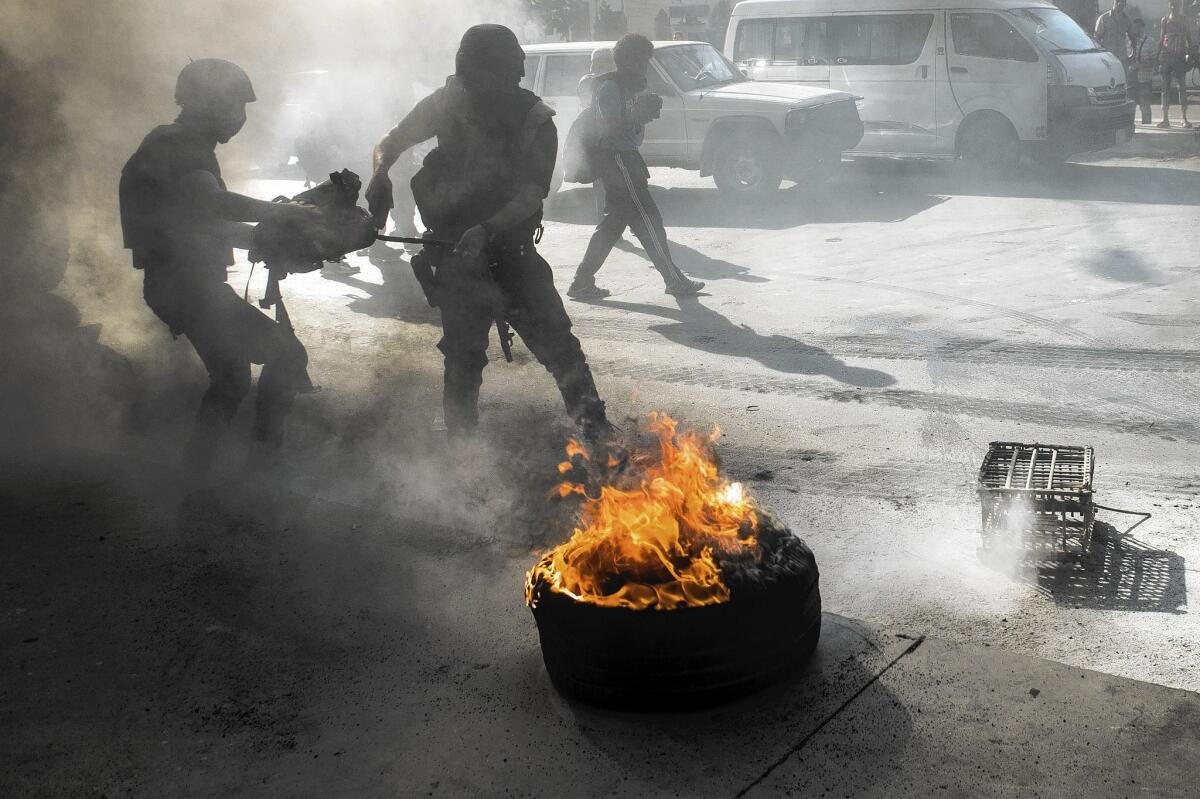 Riot police in Cairo douse burning tires thrown by protesters on the first anniversary of the military coup that ousted President Mohamed Morsi.