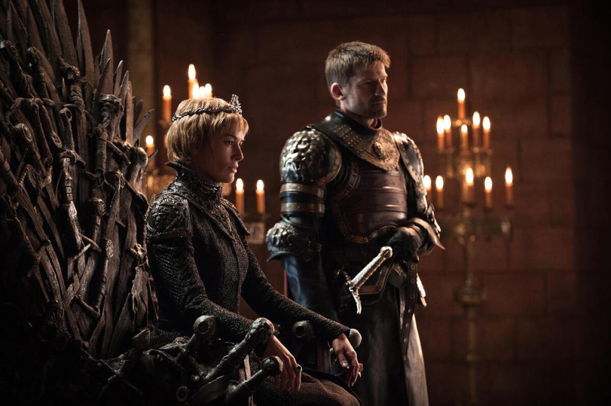 Lena Headey sitting on a throne alongside Nikolaj Coster-Waldau in "Game of Thrones."