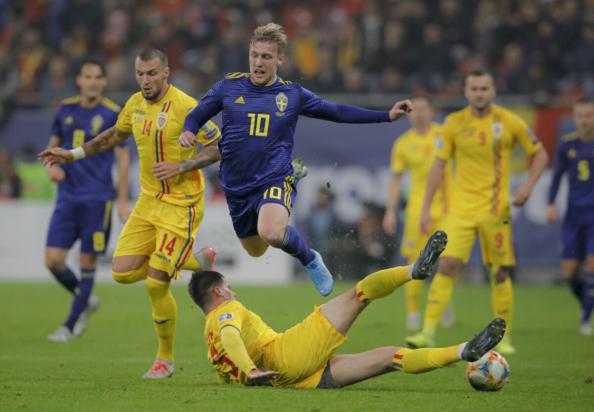 FILE - In this Friday, Nov. 15, 2019 filer, Sweden's Emil Forsberg. top, is tackled by Romania's Tudor Baluta during the Euro 2020 group F qualifying soccer match between Romania and Sweden on the National Arena stadium in Bucharest, Romania. (AP Photo/Vadim Ghirda, File)