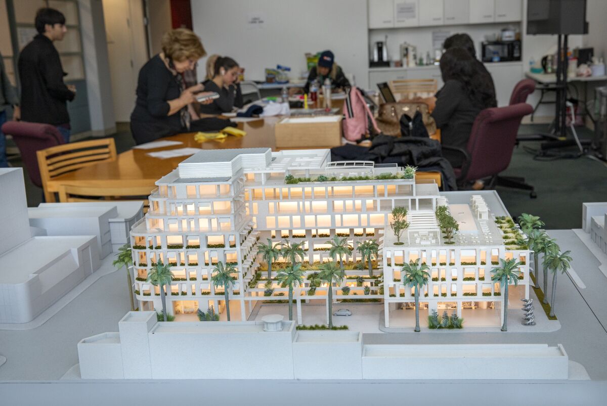 A model of the proposed Cheval Blanc hotel in Beverly Hills with phone bankers in the background
