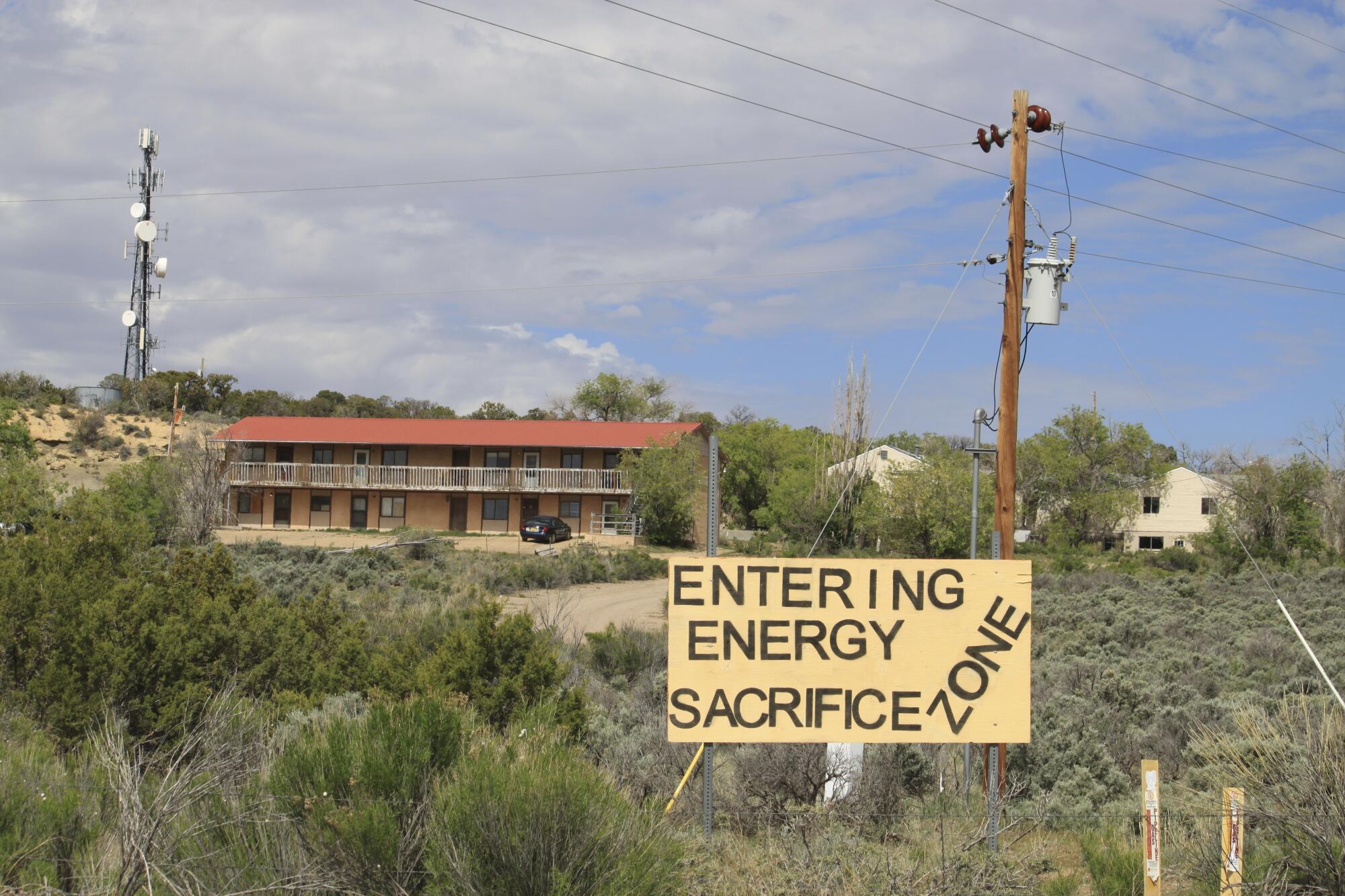 A sign of protest sayinf Entering Energy Sacrifice Zone stands on a hillside in Counselor, N.M.