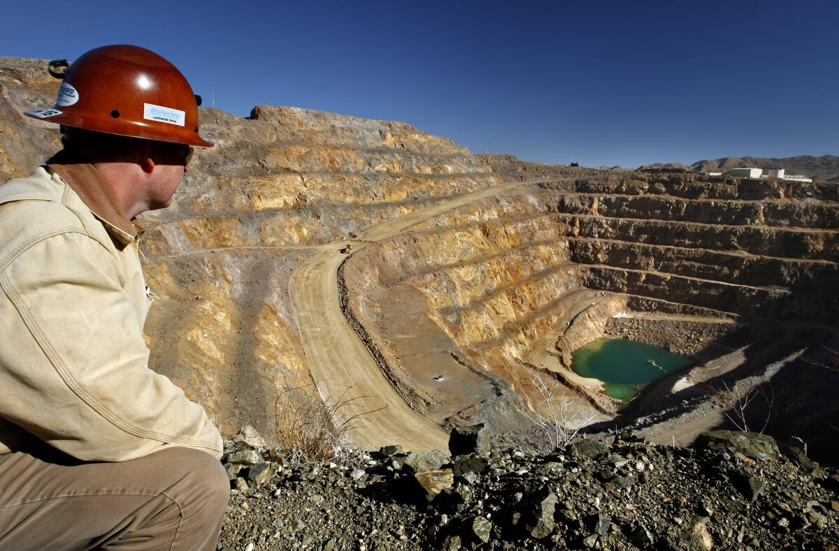 Environmental manager Scott Honan gazes across a 400-foot-deep Molycorp rare-earth mine in Mountain Pass, Calif. The open pit is off Interstate 15 near the California-Nevada border.