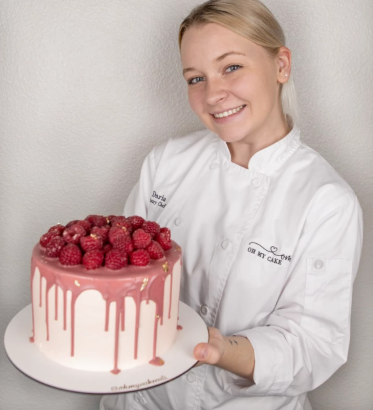 Daria Nadar, owner of "Oh My Cake" bakery holds a tall round cake