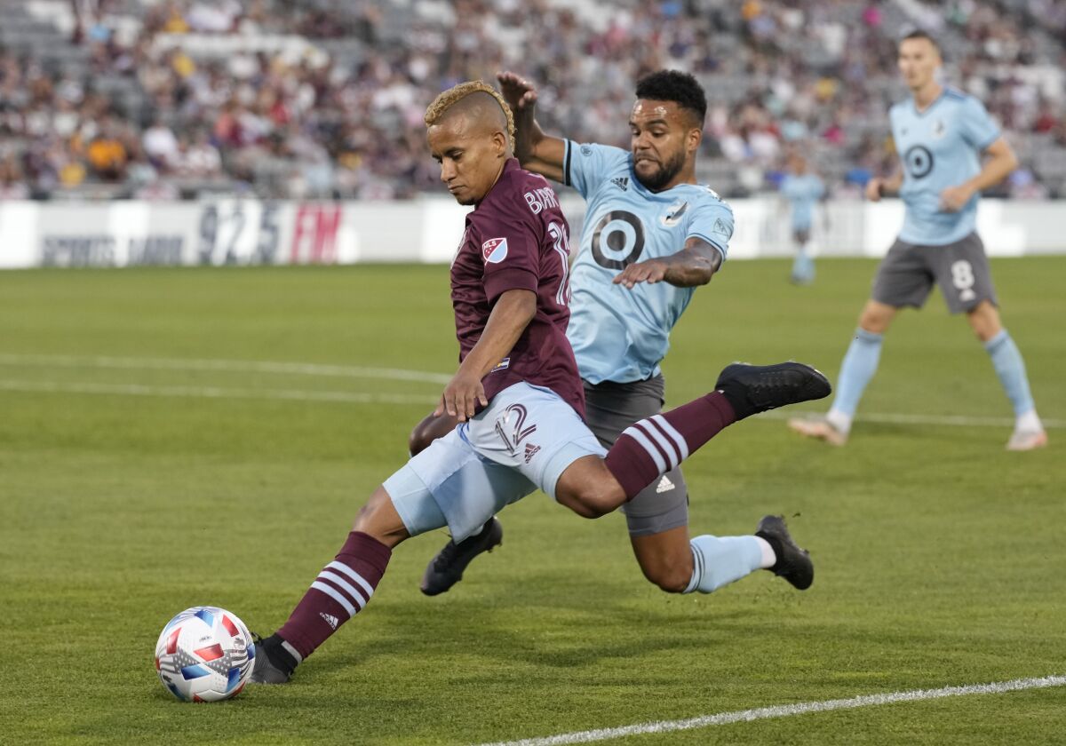 Colorado Rapids forward Michael Barrios, front, uncorks a shot on the net as Minnesota United's D.J. Taylor defends during the second half of an MLS soccer match Wednesday, July 7, 2021, in Commerce City, Colo. (AP Photo/David Zalubowski)