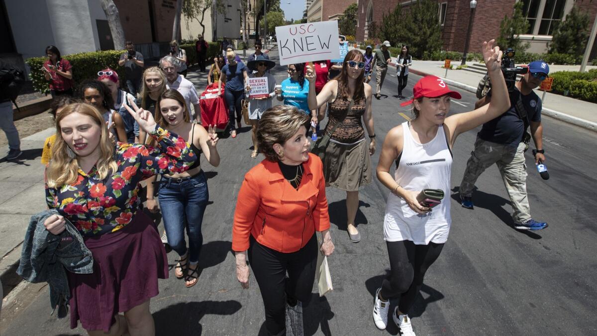 Attorney Gloria Allred, center, joins a march Saturday at USC to protest officials' handling of sexual misconduct allegations involving a former university gynecologist.