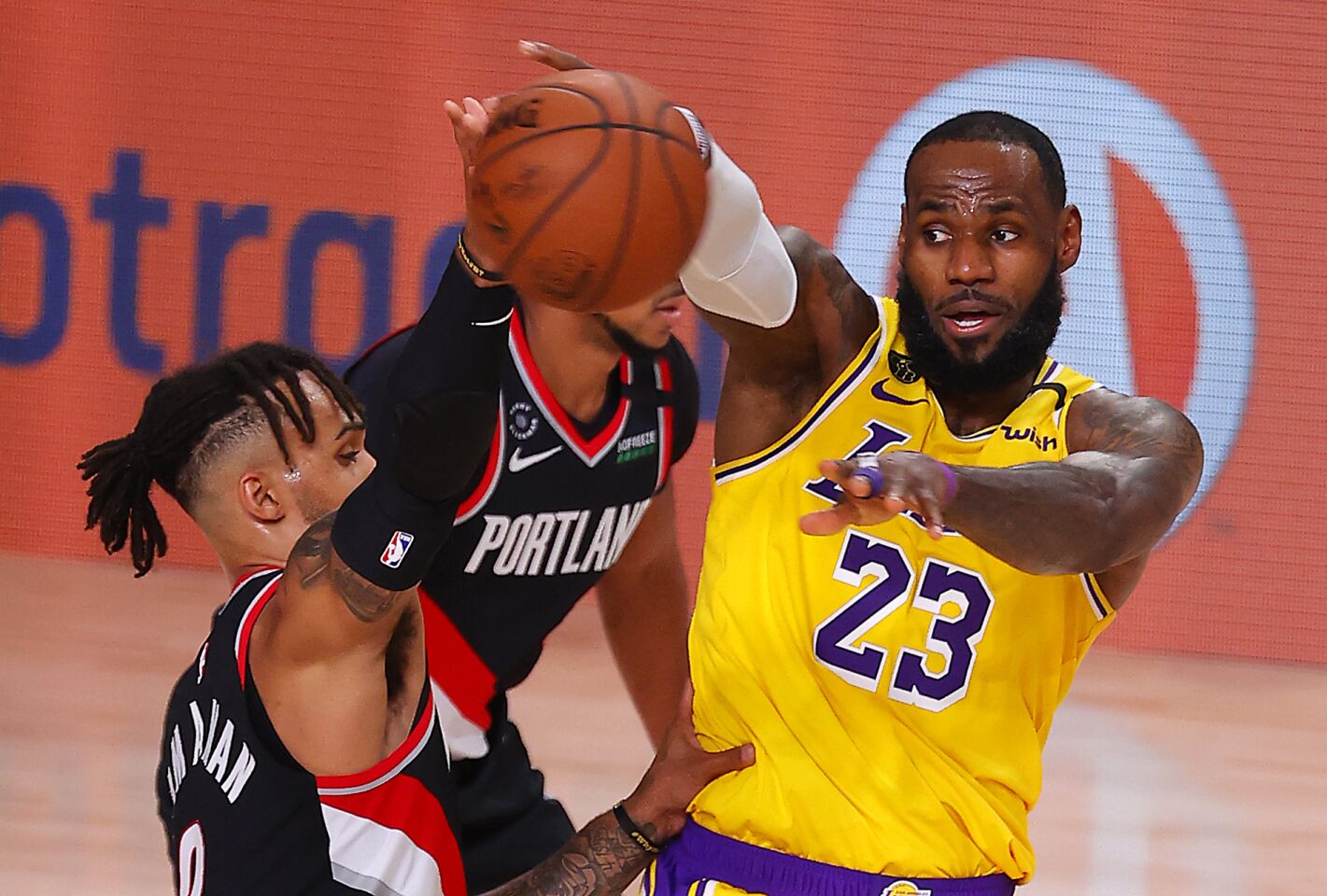 Lakers forward LeBron James tries to pass around Portland's Gary Trent Jr. during the first half.