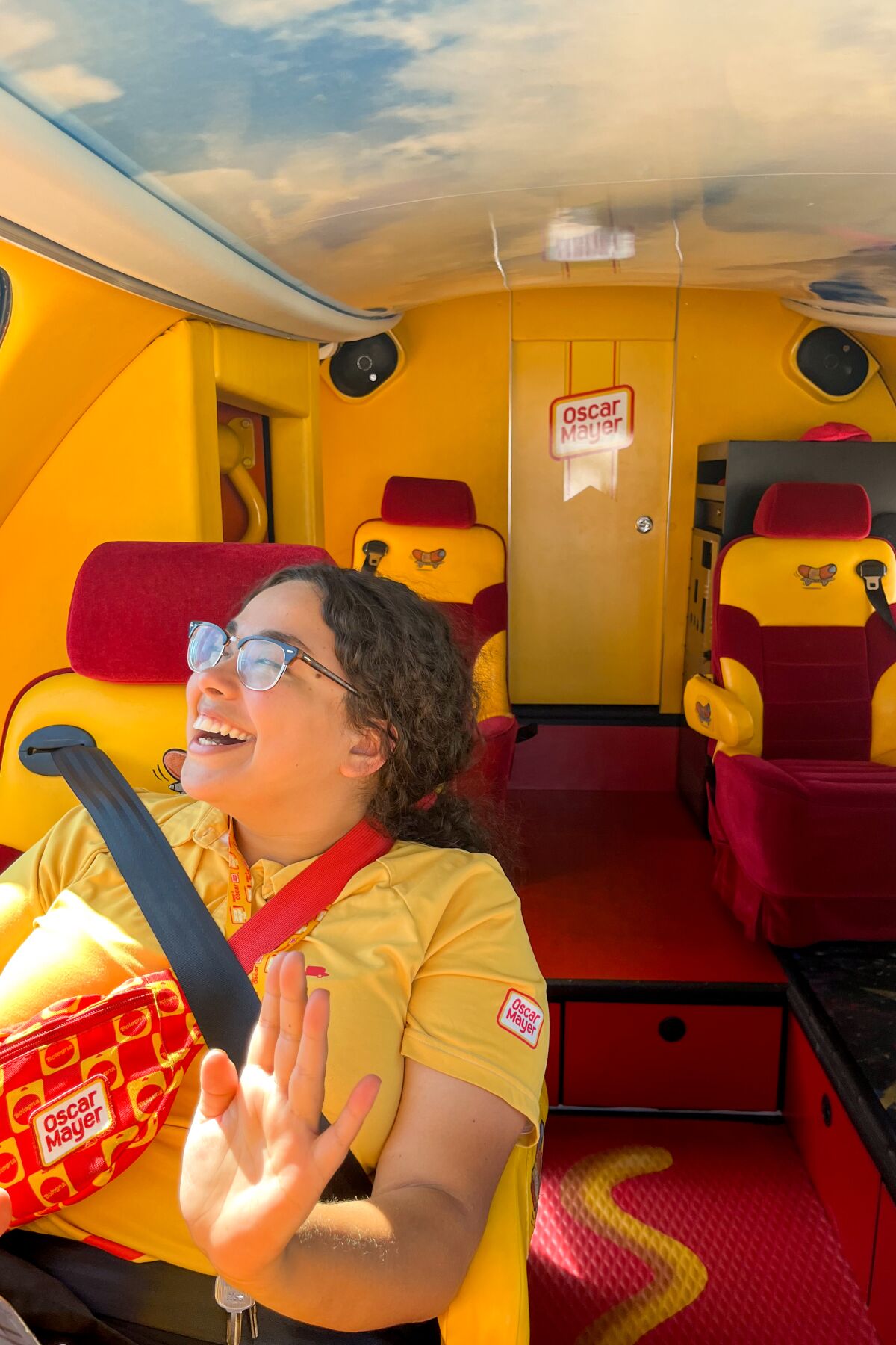 Hotdogger Keila Garza, Oscar Mayer Wienermobile ile dolaşırken sırıtıyor.