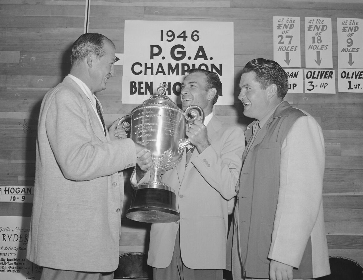 FILE - Ben Hogan gets the PGA Championship trophy from PGA president Ed Dudley, left, after winning the golf tournament in Portland, Oregon, in this Aug. 25, 1946, file photo. Hogan beat Ed Oliver, right, 6 and 4. It was 75 years ago when Ben Hogan won the first of his nine majors at the 1946 PGA Championship.(AP Photo/Paul Wagner, File)