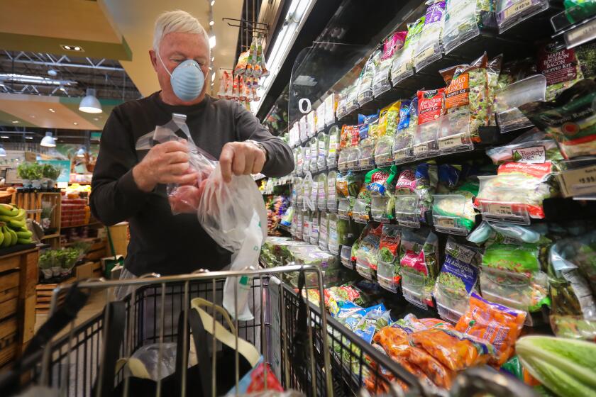 Chuck Pennell of Bankers Hill, wearing a face mask, shops in the Barons Market, North Park location, during the seniors-only time, one hour before the store opened to the general public, March 20, 2020 in San Diego, California. The seniors-only shopping is one of the many byproducts of the coronavirus outbreak, because older adults are one of the most vulnerable groups along with people with underlying heath issues are more susceptible to the virus.