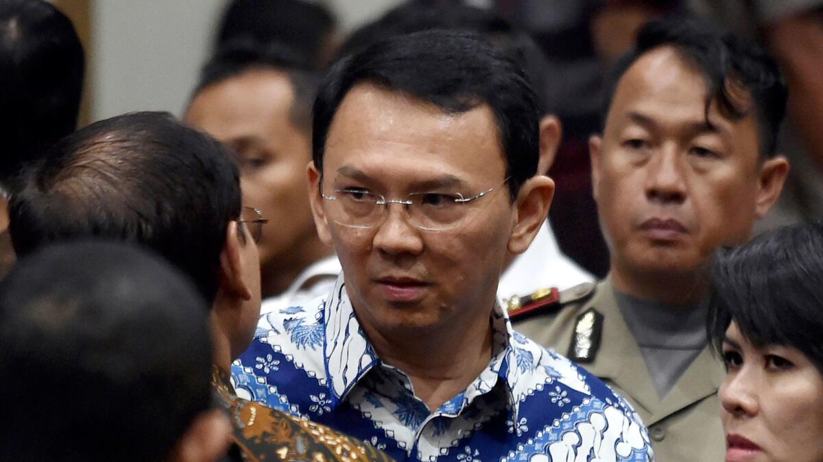 Jakarta Gov. Basuki "Ahok" Tjahaja Purnama, center, talks to his lawyers after his sentencing hearing at a court in the Indonesian capital on May 9, 2017.