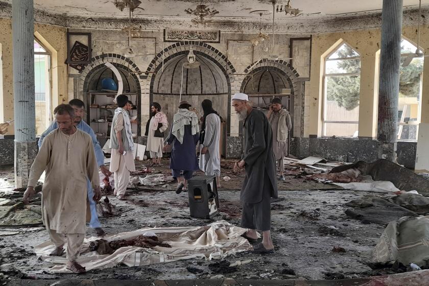 People view the damage inside of a mosque following a bombing in Kunduz, province northern Afghanistan, Friday, Oct. 8, 2021. A powerful explosion in the mosque frequented by a Muslim religious minority in northern Afghanistan on Friday has left several casualties, witnesses and the Taliban's spokesman said. (AP Photo/Abdullah Sahil)