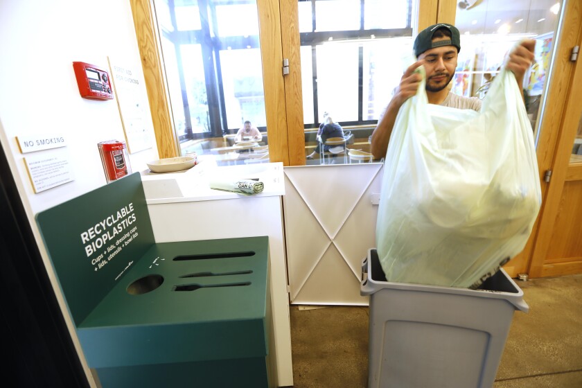 Bryan Galicia, a service worker at Sweetgreen, empties recyclables and garbage last month at the Montana Avenue location in Santa Monica. Sweetgreen is introducing closed-loop recycling of bioplastics at its Los Angeles stores.