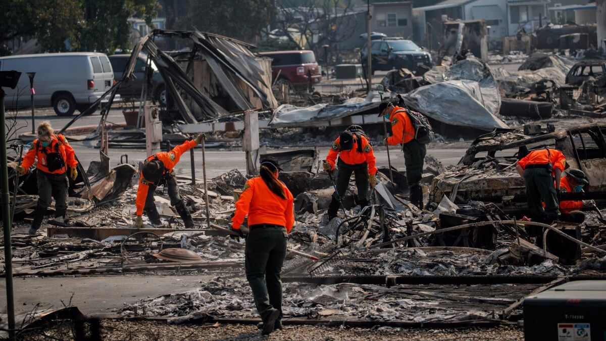 Search teams look through the debris after the Journey's End Mobile Park was destroyed by wildfires.