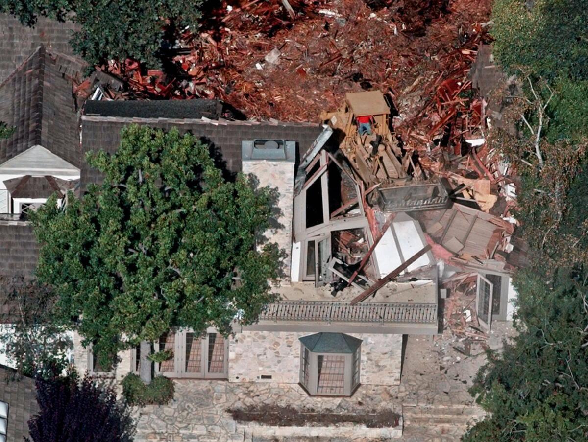 Fotografía de archivo del 29 de julio de 1998 de trabajadores demoliendo la antigua casa de O.J. Simpson en el barrio de Brentwood, en Los Ángeles. (Foto AP/Mark J. Terrill)