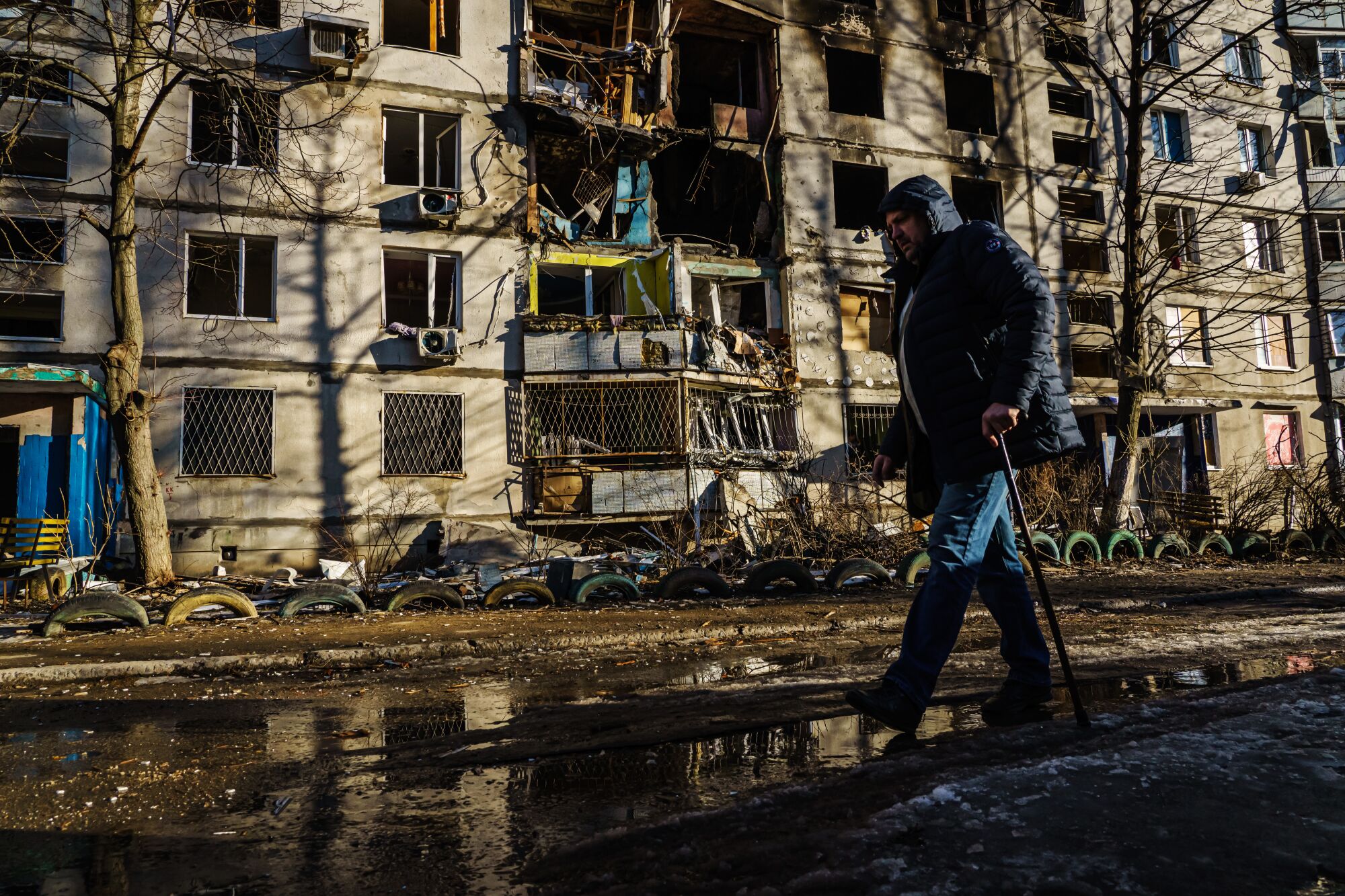A man walks past a nine-story apartment building destroyed by bombardment in Nemyshlianskyi district in Kharkiv, Ukraine.