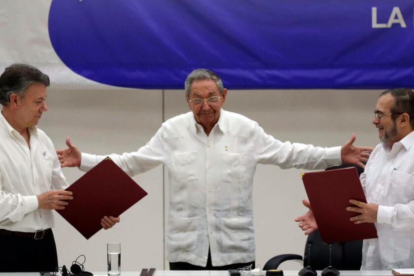 Cuban President Raul Castro, center, motions to Colombian President Juan Manuel Santos, left, and Commander of the Revolutionary Armed Forces of Colombia, Rodrigo Londono, in June during a signing ceremony for a ceasefire.