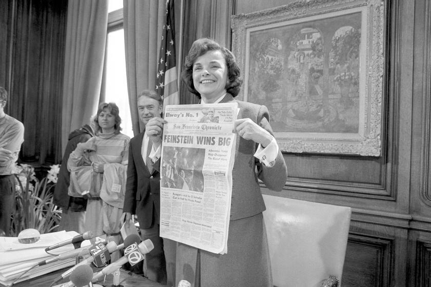 San Francisco Mayor Dianne Feinstein holds up the headlines in her office in San Francisco, Wednesday, April 27, 1983 following her sweeping victory in Tuesdays recall election. The recall was organized by the White Panthers who were angered at her support for gun control. (AP Photo/Paul Sakuma)