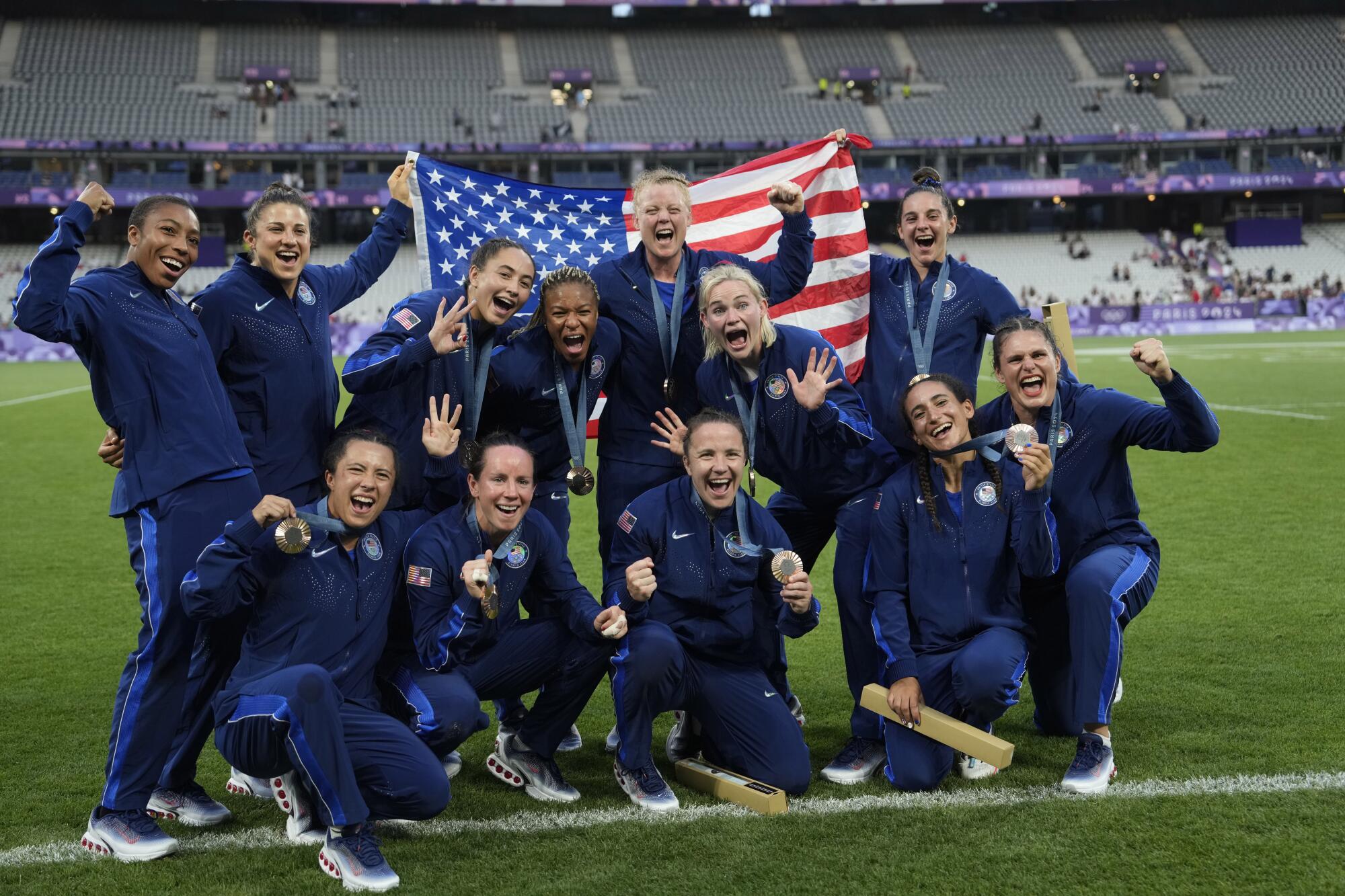 Members of the U.S. rugby sevens team pose with their bronze medals 