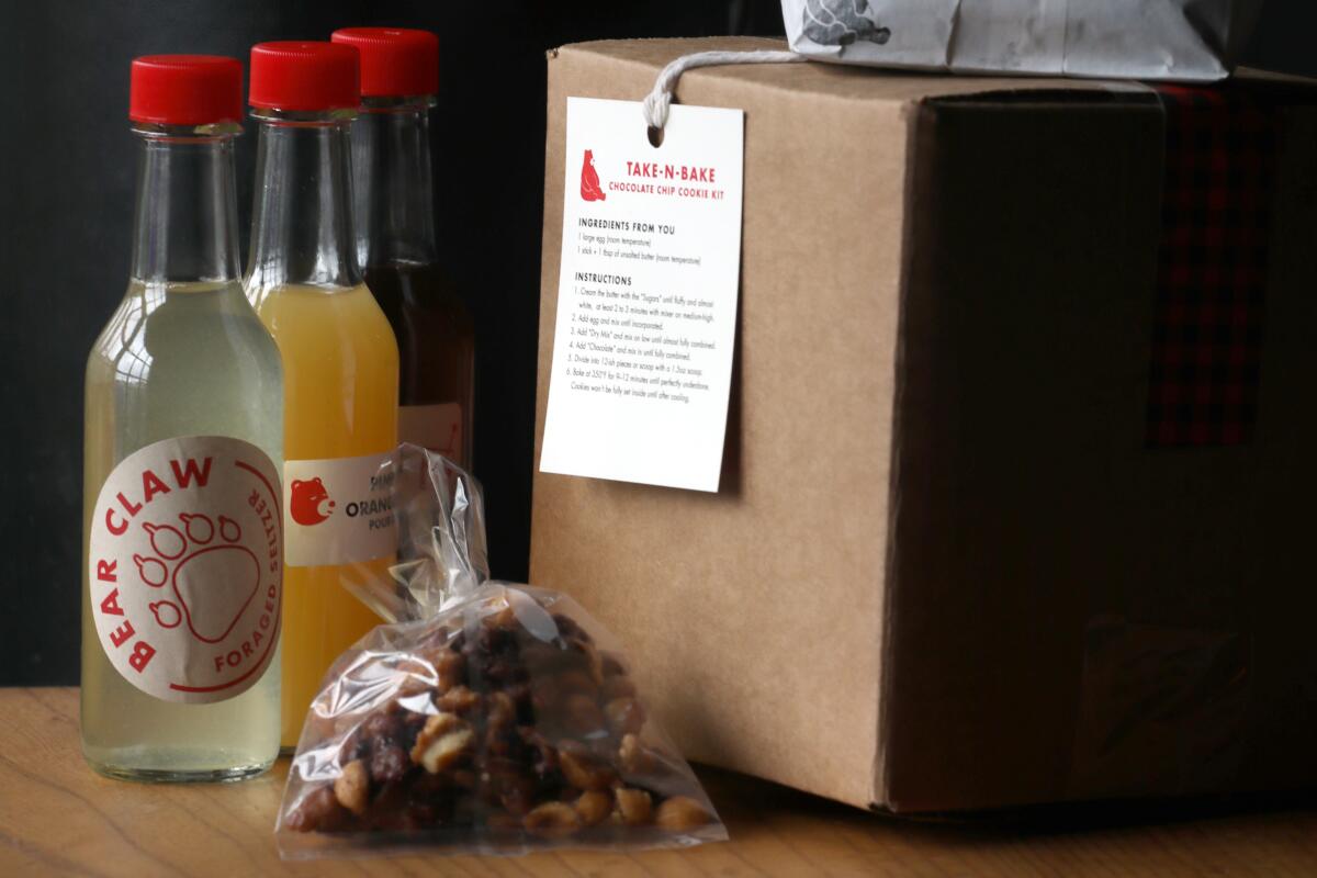 Small bottles of cocktail ingredients, with a bag and box of to-go food