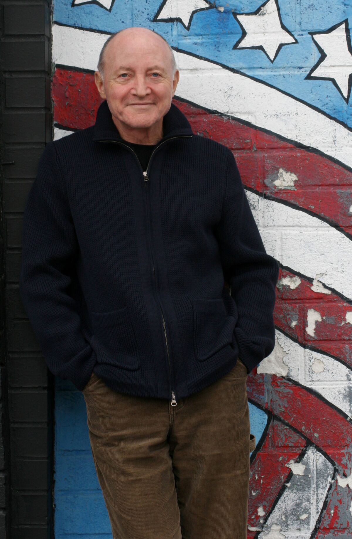 A man in front of a mural