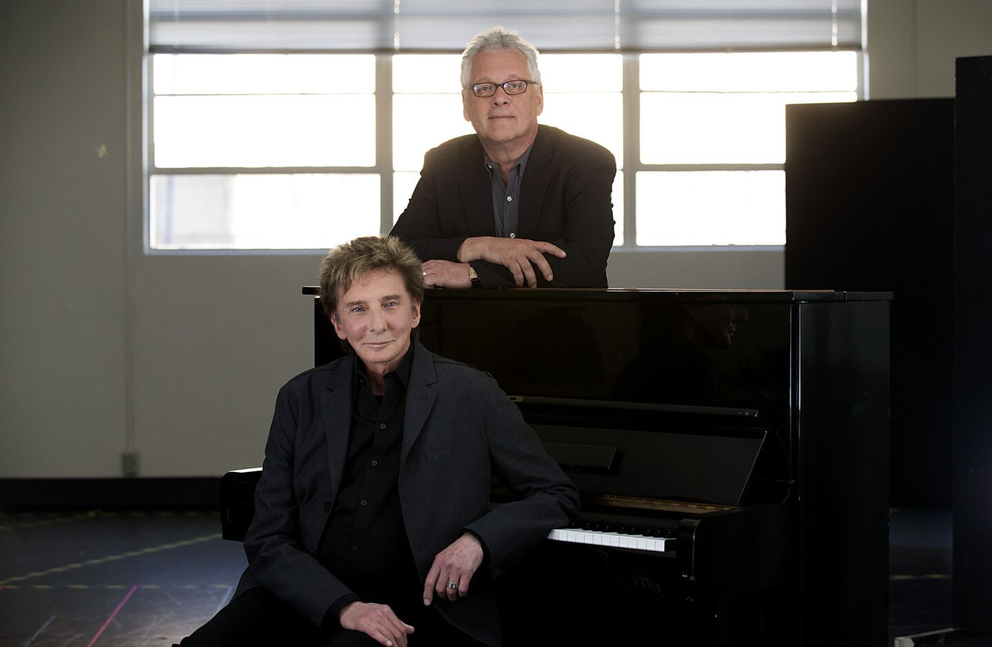 Singer-songwriter Barry Manilow, front, and writing partner Bruce Sussman at the Music Center Annex Complex. Their musical "Harmony" will be at the Ahmanson Theatre until April 13. REVIEW: Barry Manilow's 'Harmony' musical can sing but needs work