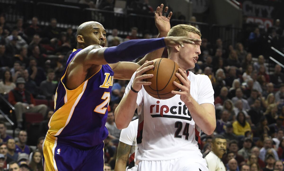 Kobe Bryant reaches in on Trail Blazers center Mason Plumlee during the first half of a game on Jan. 23.