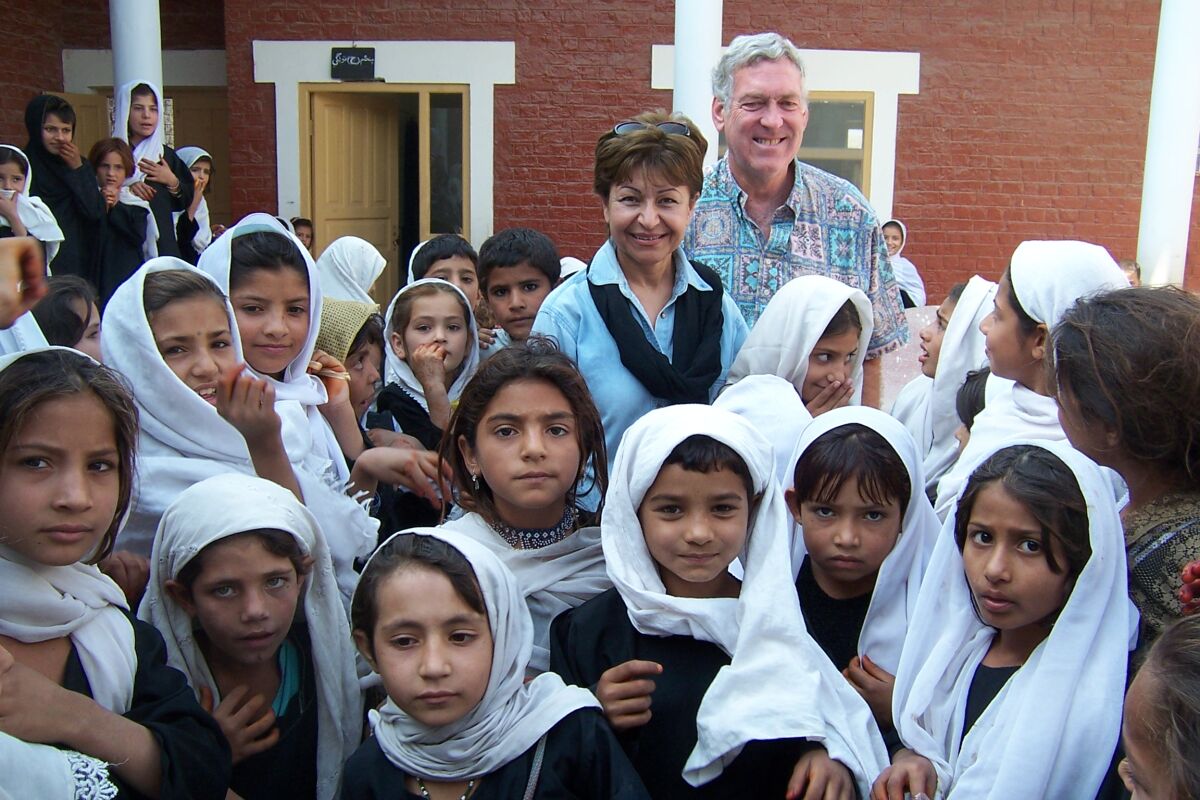 Fary Moini and Stephen Brown stand amid students at the Afghan school built by the La Jolla Golden Triangle Rotary Club.