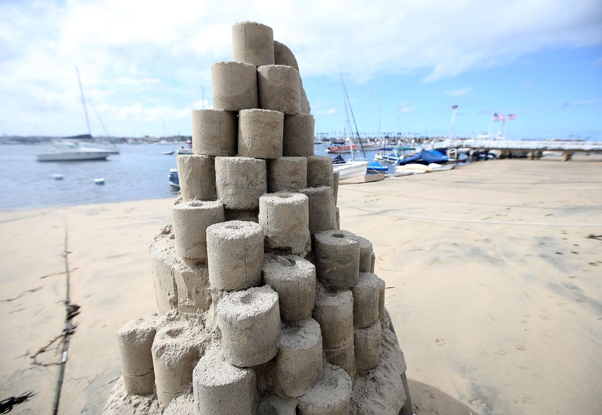 A toilet paper tower titled "Roll With It" by sandcastle artist Chris Crosson rises on Balboa Island in Newport Beach.