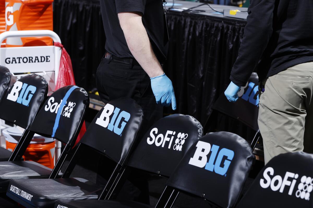 Trainers wear rubber gloves as they work in the bench area during the first round of the Big Ten Men's Basketball Tournament game between Nebraska and Indiana at Bankers Life Fieldhouse on March 11.