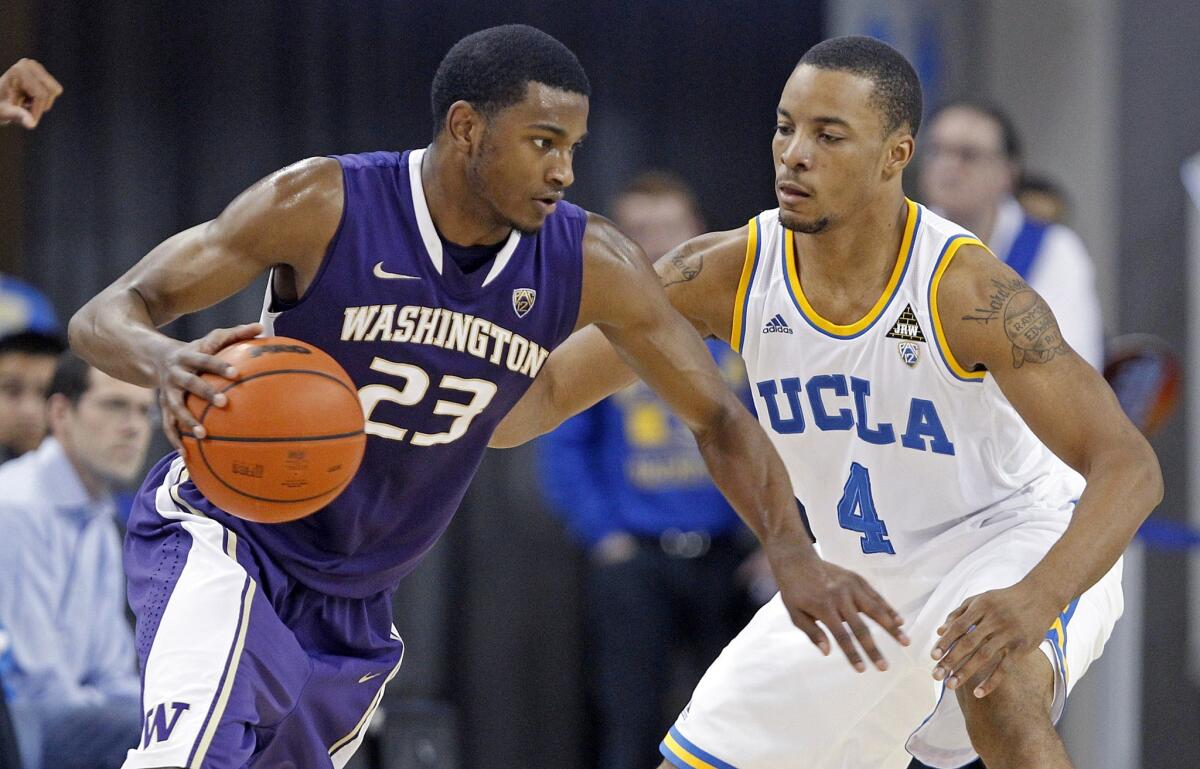 Washington's C.J. Wilcox, left, drives past UCLA's Norman Powell during a game on Feb. 7. The Clippers used a first-round draft pick to select Wilcox.