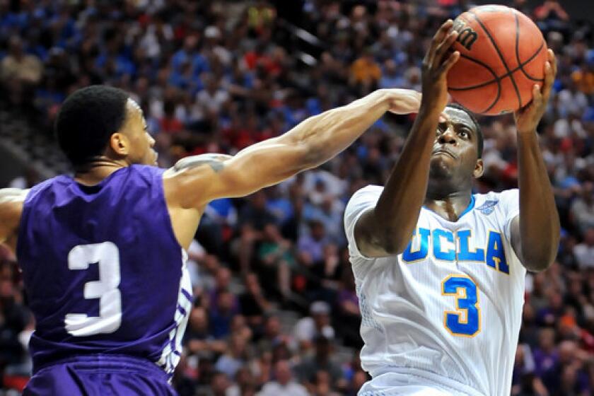 UCLA's Jordan Adams, right, scores on a shot over Stephen F. Austin's Deshaunt Walker during the Bruins' 77-60 win in the third round of the NCAA tournament Sunday. Adams' knack for scoring points or grabbing rebounds at critical junctures of games makes him a valuable asset for UCLA.