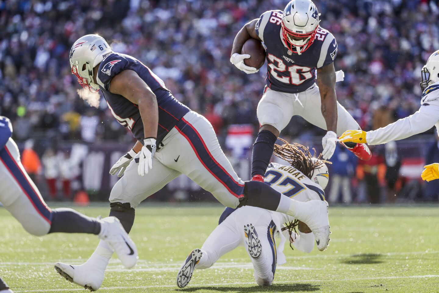 New England Patriots running back Sony Michel leaps over Chargers safety Jahleel Addae on a first quarter run in the NFL AFC Divisional Playoff at Gillette Stadium on Sunday.