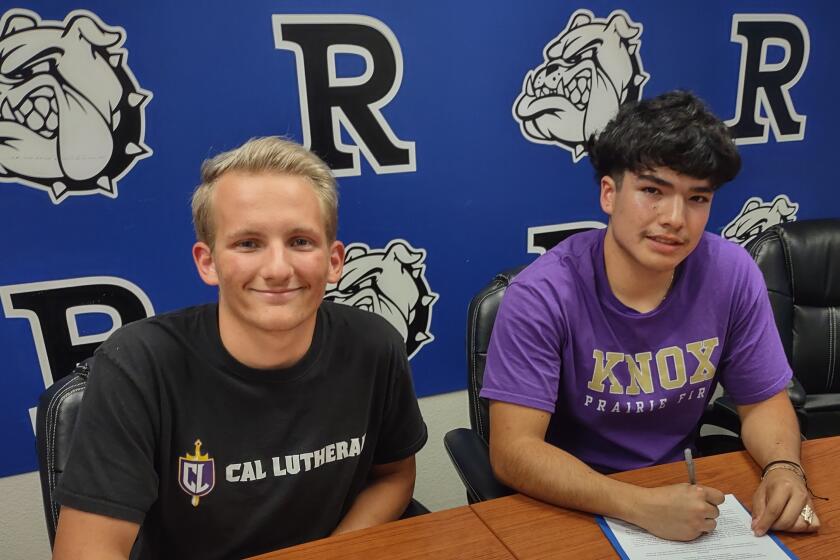 Ramona High seniors Justin Setterberg, left, and Fernando Torres Jr. sign agreements to compete in college sports.