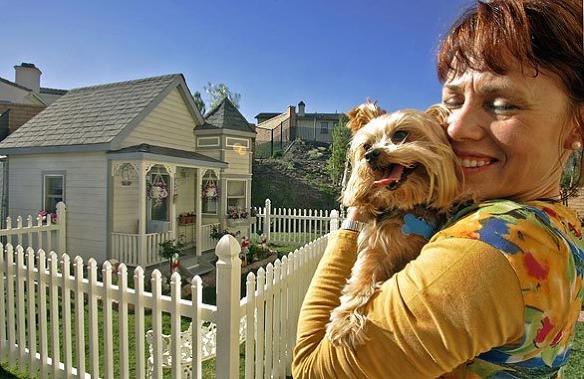Tammy Kassis holds Coco Puff in front of her Victorian doggie mansion located in the Riverside County community of Winchester. Coco Puff shares the doggie estate with fellow Yorkshire terrier Chelsea and sassy Pomeranian Darla. Five years ago, when Kassis and her husband, Sam, were living in a Victorian home in Temecula, she decided the dogs needed their own place, so they had the fancy doghouse built. When the Kassises moved to Winchester this summer, they brought the 5,000-pound home with them.