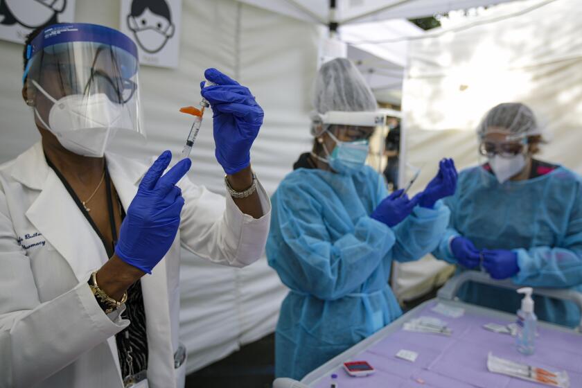 Los Angeles, CA - January 07: Director pharmacy Gayle Butler, left, and nurse Cherry Costales, center, prepare Pfizer-BioNTech COVID-19 vaccine at St. John's Well Child & Family Center on Thursday, Jan. 7, 2021 in Los Angeles, CA. (Irfan Khan / Los Angeles Times)