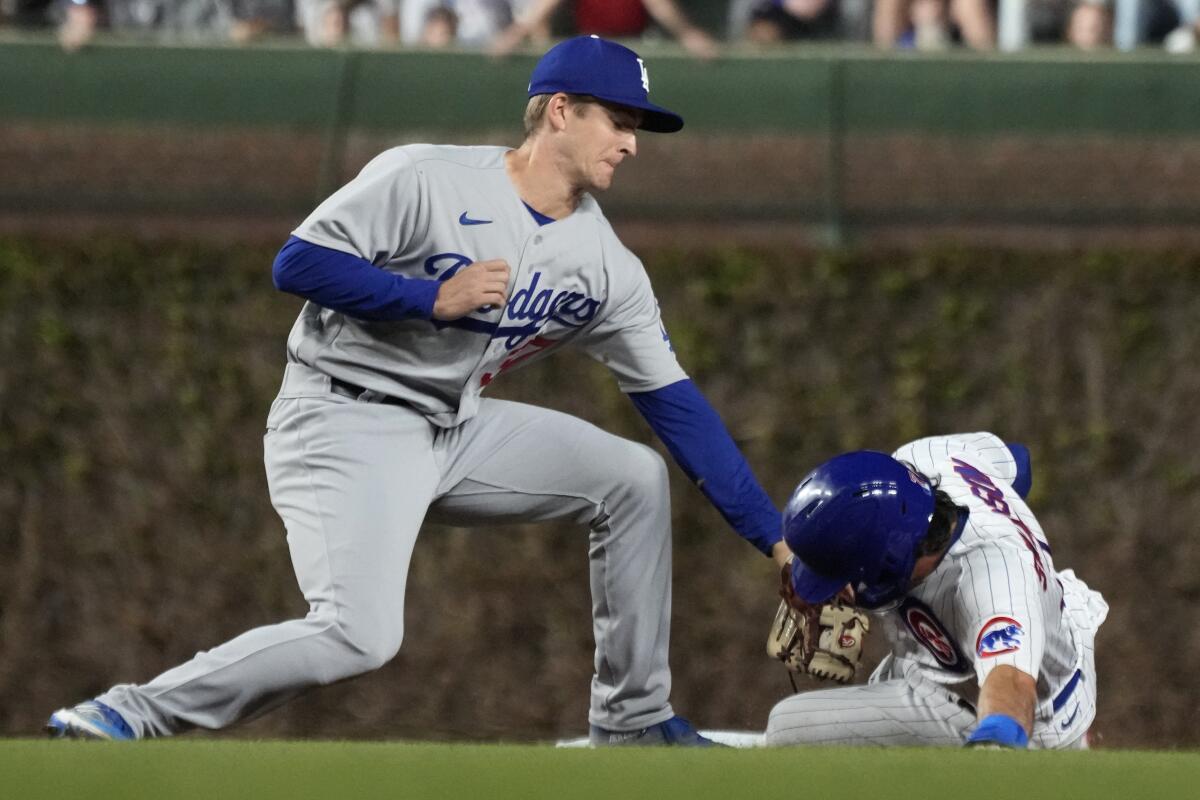 Chicago Cubs' Dansby Swanson advances to second base as Dodgers shortstop Luke Williams applies a late tag.