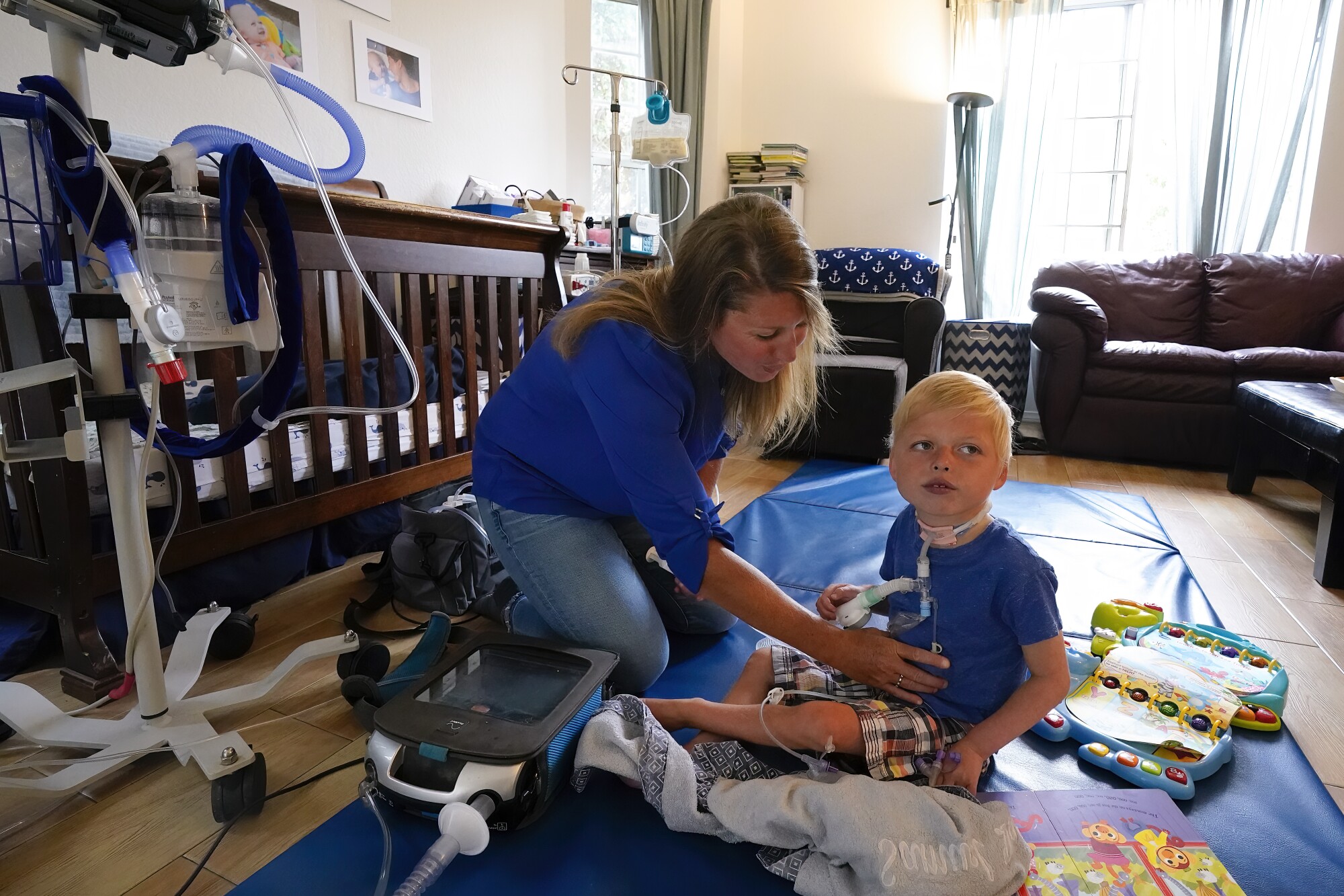 Ali Tebbs checks on her son, Samuel's feeding tube with his formula.