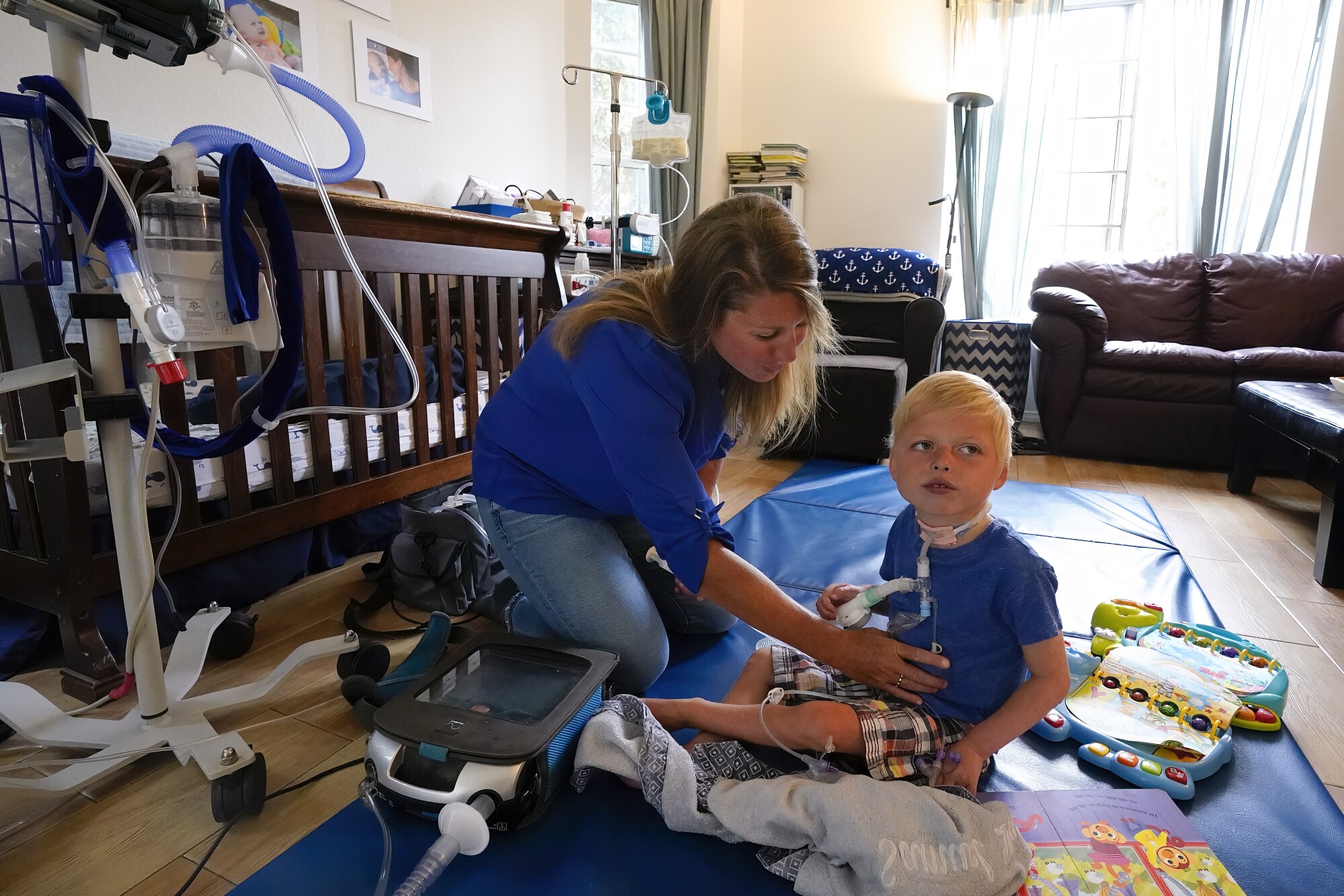 Ali Tebbs checks his son Samuel's feeding tube with infant formula. 