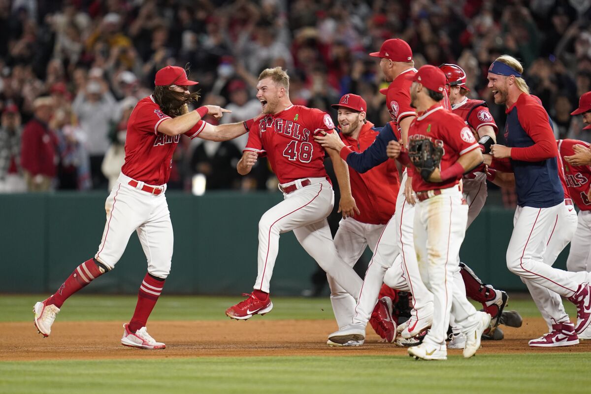 Angels players leap to surround Reid Detmers after he threw a no-hitter.