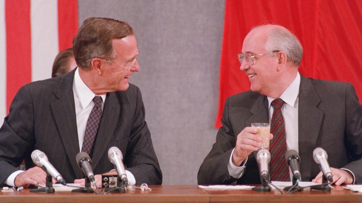 President George H.W. Bush, left, and Soviet counterpart Mikhail Gorbachev laugh during a news conference on July 31, 1991, in Moscow.