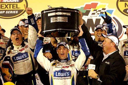 Jimmie Johnson lifts the trophy while surrounded by his crew after winning the Dayonta 500 on Sunday.