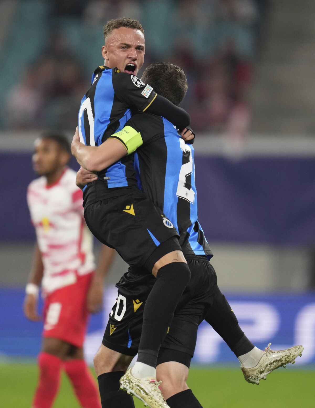 Brugge's Hans Vanaken, right, celebrates with Brugge's Noa Lang after scoring his sides first goal during the Group A Champion's League soccer match between RB Leipzig and Club Brugge at the Red Bull Arena in Leipzig, Germany, Tuesday, Sept. 28, 2021. (AP Photo/Michael Sohn)