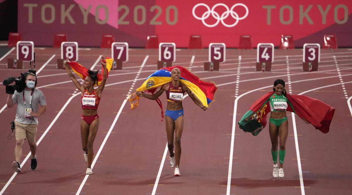 La venezolana Yulimar Rojas (centro) tras ganar la medalla de oro del salto triple de los Juegos Olímpicos de Tokio