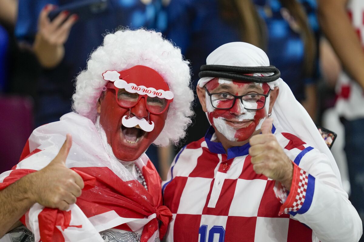 FILE - Croatia and Canada fans cheer ahead of the World Cup group F soccer match between Croatia and Canada, at the Khalifa International Stadium in Doha, Qatar, Sunday, Nov. 27, 2022. At a World Cup that has become a political lightning rod, it comes as no surprise that soccer fans’ sartorial style has sparked controversy. At the first World Cup in the Middle East, fans from around the world have refashioned traditional Gulf Arab headdresses and thobes. (AP Photo/Darko Vojinovic, File)