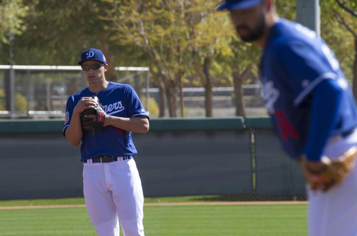 Dodgers shortstop Corey Seager, left, gets ready for infield drills during spring training.