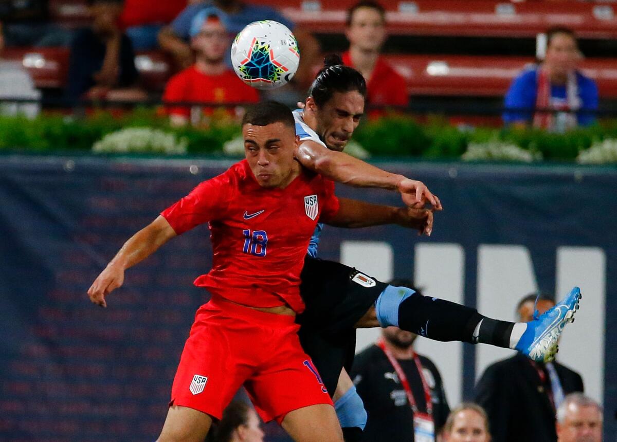 U.S. defender Sergiño Dest, front, heads the ball in front of Uruguay's Martín Caceres.