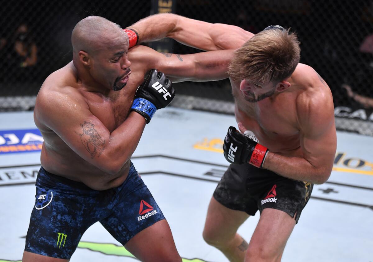Stipe Miocic (R) punches Daniel Cormier in their UFC heavyweight championship bout during UFC 252.