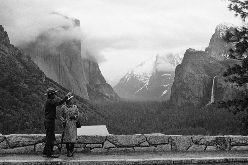 FILE - In this March 5, 1983 file photo taken by Walt Zeboski, park superintendent Bob Binnewies points out highlights from Inspiration Point to Queen Elizabeth II during her visit to Yosemite National Park, in California. Walt Zeboski, who chronicled Ronald Reagan's 1980 presidential campaign and a succession of California governors as a photographer for The Associated Press, has died. He was 83. (AP Photo/Walt Zeboski, File)