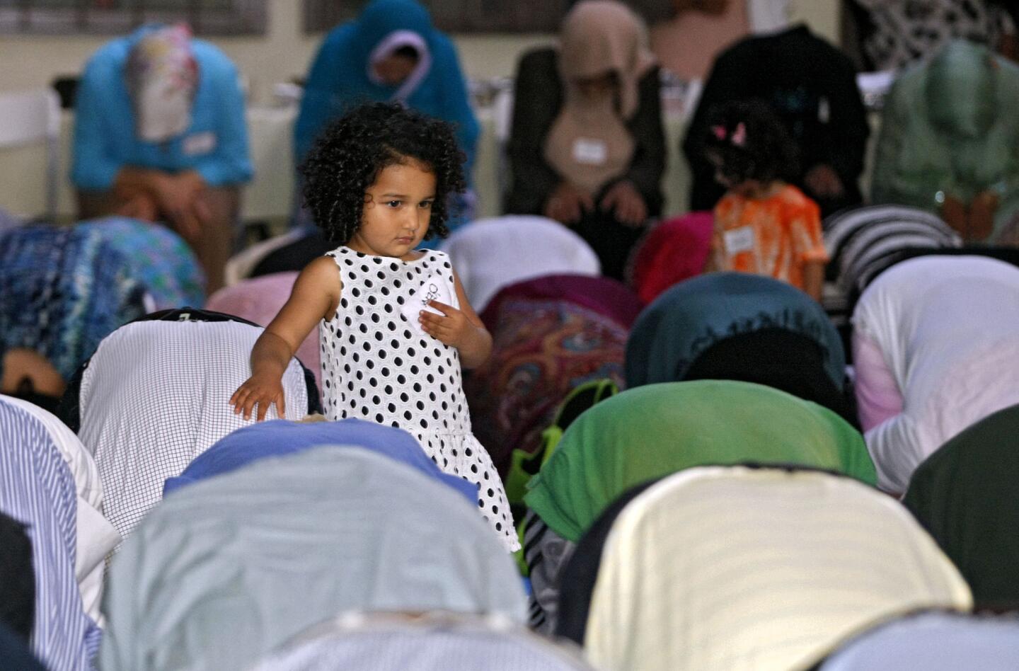 Reya Etman, 2 of La Canada Flintridge, stands next to her father Mohamed Etman during the Ramadan Maghrib, evening prayer, at the Community Center of La Canada Flintridge on Friday, July 12, 2013. About 150 people attended the Iftar, breaking of fast, and the short prayer before eating a pot luck meal after sundown. The event was put on by the Islamic Congregation of La Canada Flintridge.